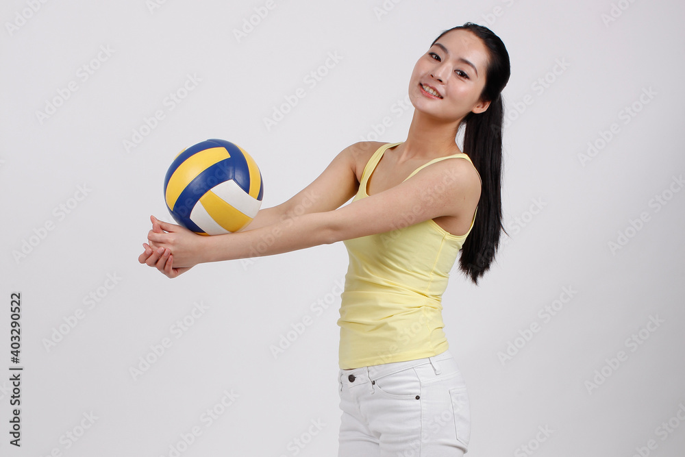 A happy young beauty woman playing volleyball 