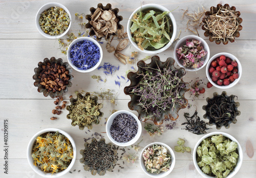 Assortment of dried herbs  blossom  root and seed  flat on the table  lavender  chamomile  lime  rose  cornflower  meadowsweet  thyme and others overhead top view  naturopathy and medicine concept