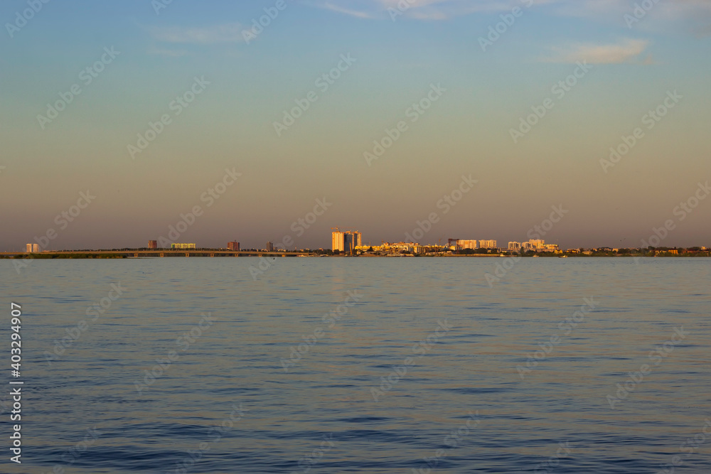 View of the city and the bridge from the opposite bank of the river. View of the houses on the opposite bank of the river.