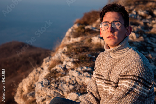 Young guy in a sweater. Mountain landscape. Portrait photographs. Emotions and feelings.