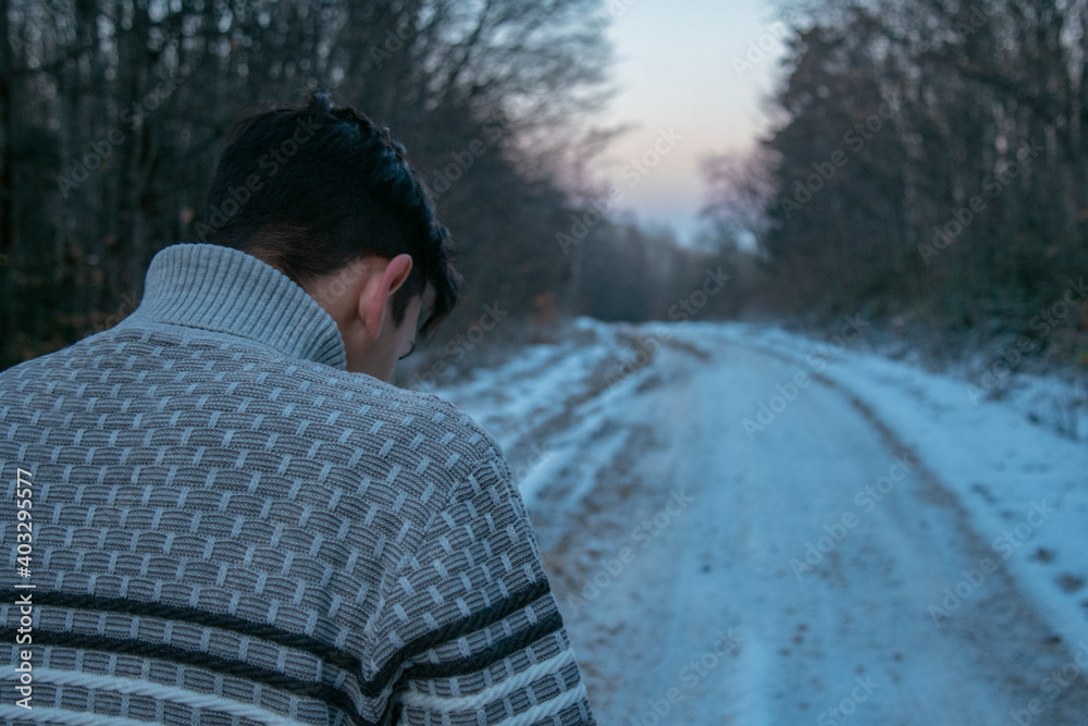 A young guy in a sweater walks through the woods. Winter landscape. Human harmony with nature. A young guy in a sweater walks through the woods. Winter landscape. Human harmony with nature.