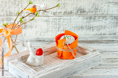 Easter spring composition with painted eggs, ceramics bunny and little birds on twigs. Festive decoration for Easter holidays with tasty easter cake or kulitch photo