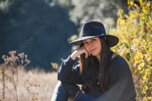 Portrait of an adventurous girl, exploring new trails, dressed in black, with a blue backpack, hat and a black backpack. 14 © Marco