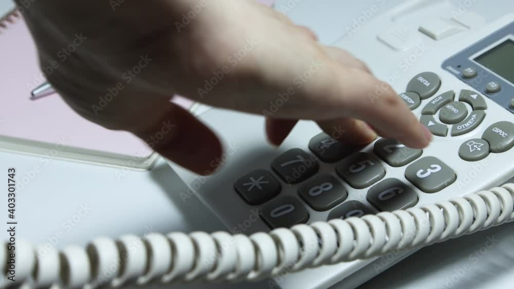 Close shot of how to dial a phone number on a wired phone. Close shot of how to dial a phone number on a wired phone.