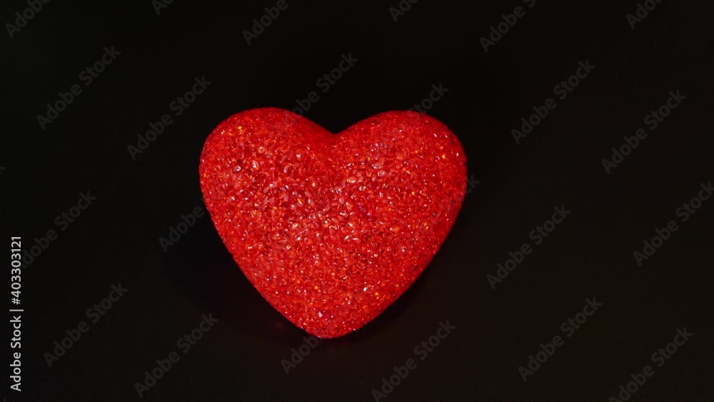 Valentine's Day. A red glowing heart spins and blinks against a black background. Stop motion, 4K. Valentine's Day. A red glowing heart spins and blinks against a black background. Stop motion, 4K.