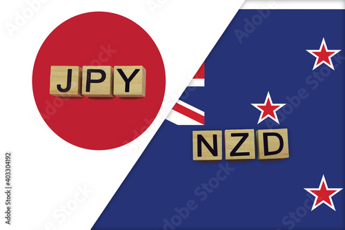 Japan and New Zealand currencies codes on national flags background photo