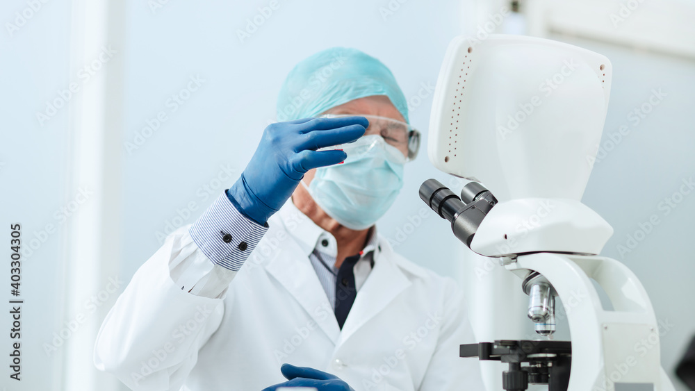 Fototapeta premium scientist in with an ampoule sitting at a laboratory table .