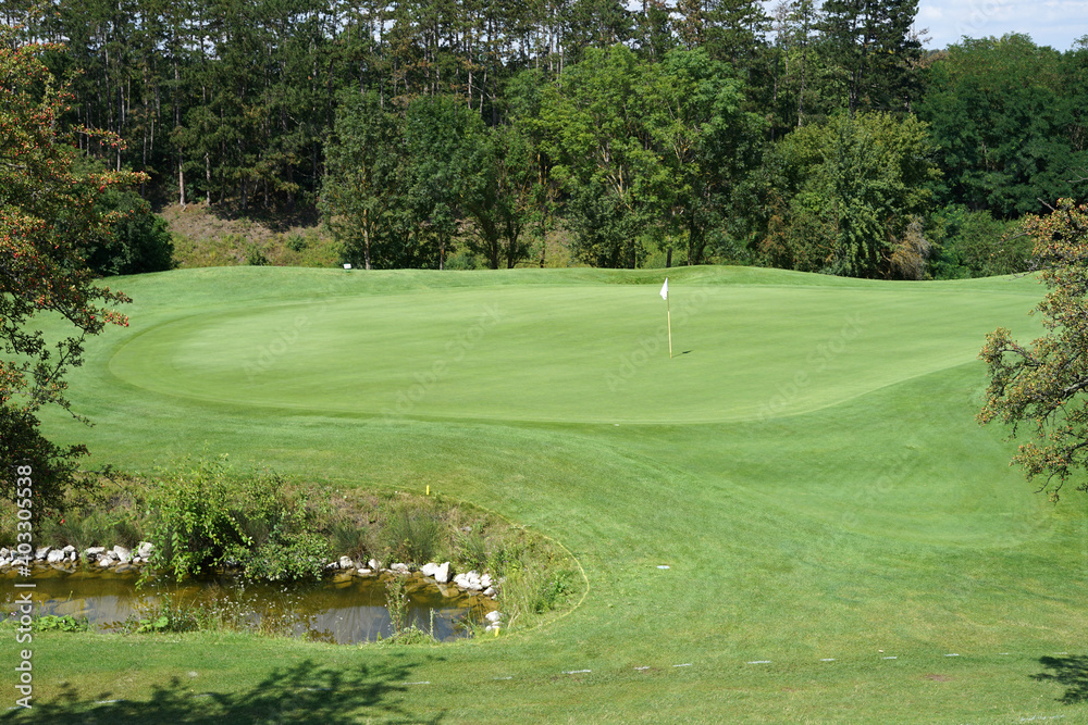 Artificial pond hazard in front of green, golf concept Artificial pond hazard in front of green, golf concept