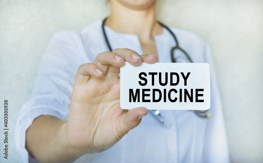 A doctor in a white coat holds a card with the inscription, medical concept. A doctor in a white coat holds a card with the inscription, medical concept.