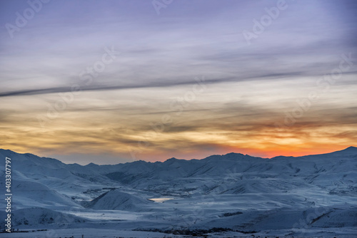 Beautiful winter landscape. The mountains peaks snow-covered on the sunset. Dramatic sky. © Inga Av