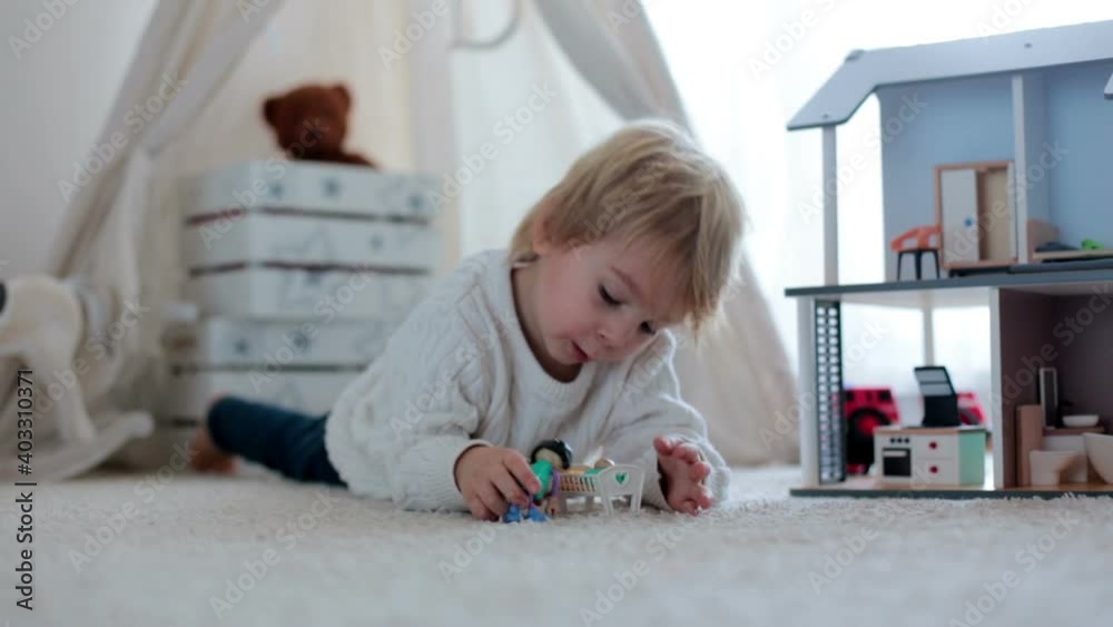 Cute toddler child, playing with toys at home in sunny room Cute toddler child, playing with toys at home in sunny room