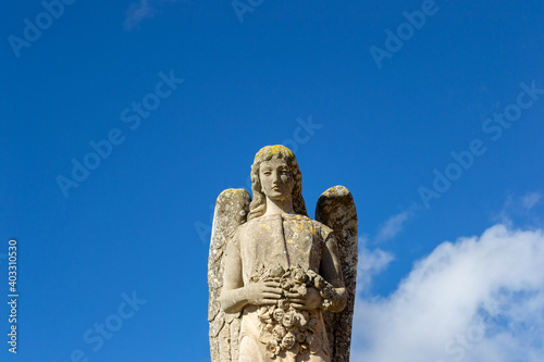 An old beautiful melancholic and delicate sculpture statue at the llucmajor cemetery in mallorca island balearic spain on a sunny clear day 