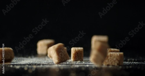 Brown sugar cubes fall on the table. 