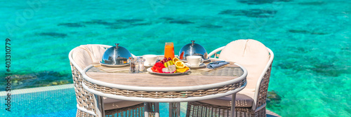 Vacation breakfast table at luxury restaurant or hotel room panoramic banner. Romantic cruise honeymoon travel holiday in Maldives or Tahiti. © Maridav
