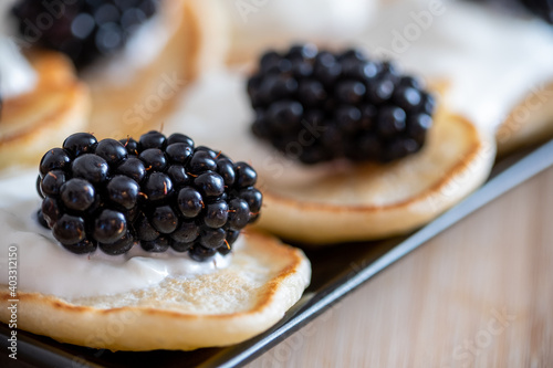 Pancakes served with black currant and blackberry. Dessert and breakfast concept