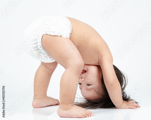 Konstfotografi cute baby boy in diaper wants to turn somersaults isolated on white background