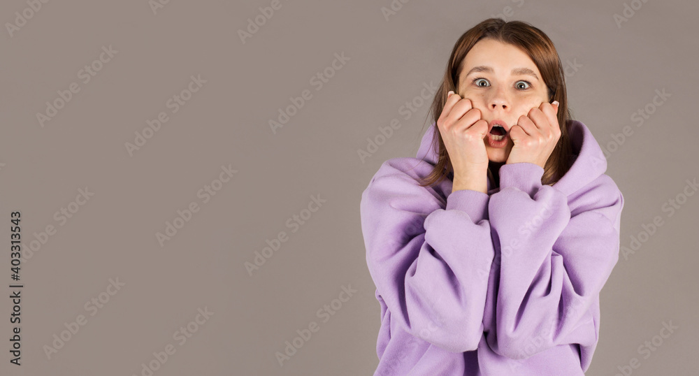 Amazed woman looking at camera isolated on a gray background Amazed woman looking at camera isolated on a gray background