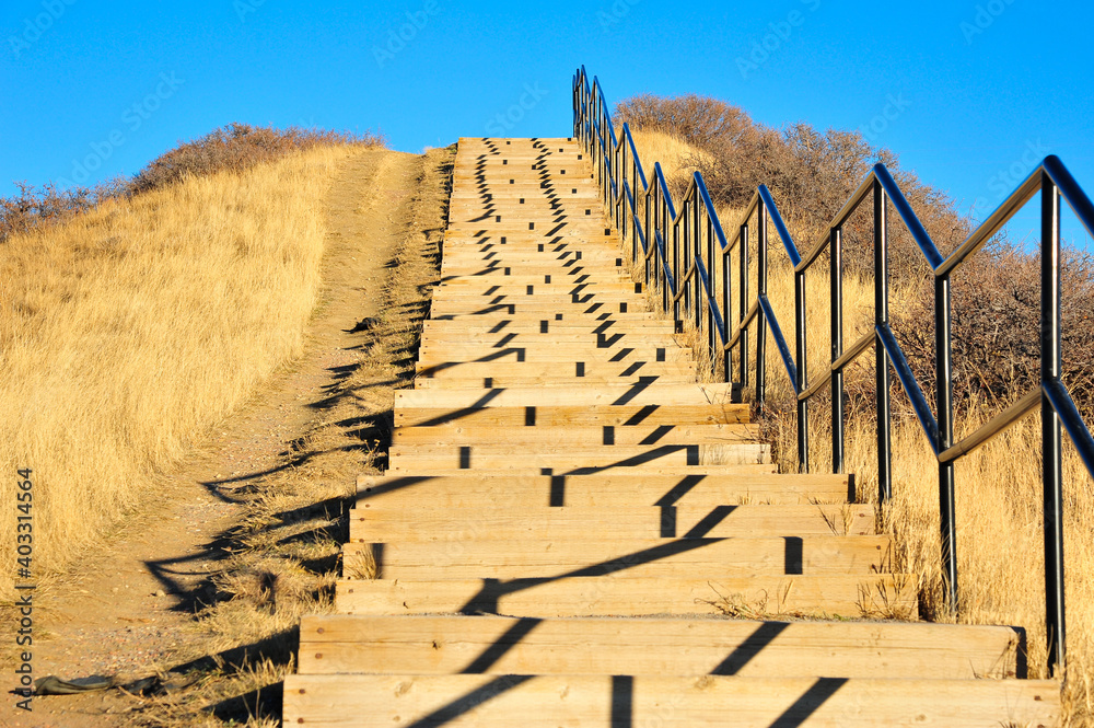 Steep stairs ascend to the city of Lethbridge, Alberta cast abstract shadows from the setting sun in the valley