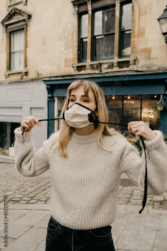 Young Woman Putting on a face mask outdoors