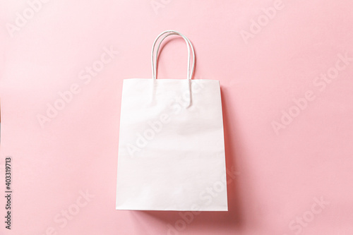 Simply minimal design shopping bag isolated on pink pastel background. Online or mall shopping shopaholic concept. Black friday Christmas season sale. Flat lay top view copy space, mock up