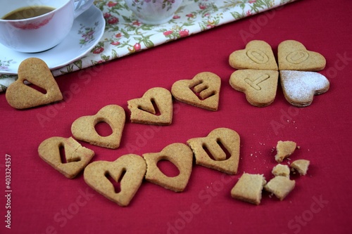 I love you too, inscription with cookies, drunk coffe, lipstic on cup, crumbs, red background, przy walentynkowej kawie