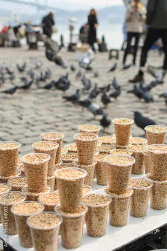 Man sell bird seeds for pigeons. Feeding doves in Ortakoy square, Istanbul, Turkey. photo