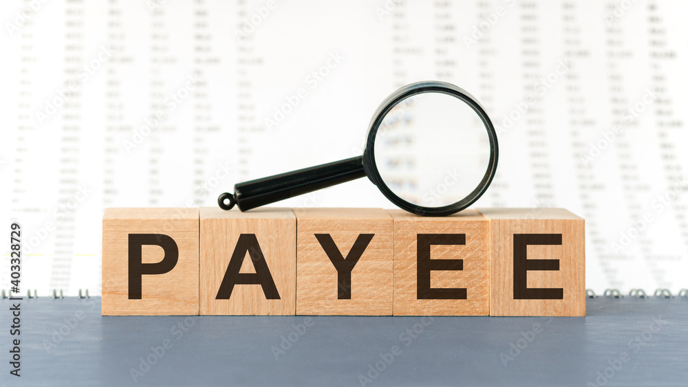 Wooden blocks with the text: payee with magnifying glass Wooden blocks with the text: payee with magnifying glass