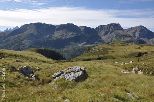 Trawiaste zbocza gór widziane z łąki, Dolomity