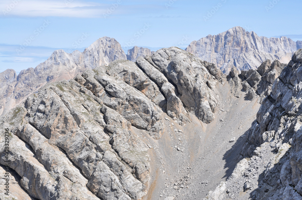 Fototapeta premium Wapienne zbocza górskie ze stromym żlebem, Dolomity