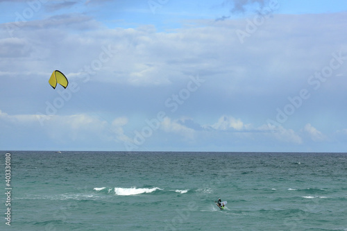 Kite surfer catching some air on his foil board.