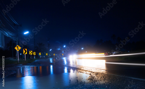 Night scene of wet street after hard rain fall with blurry cars and light reflections,long-exposure shot.