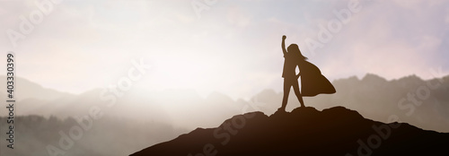 Fotografia silhouette of a girl who dreams of being a superhero in a beautiful mountain lan