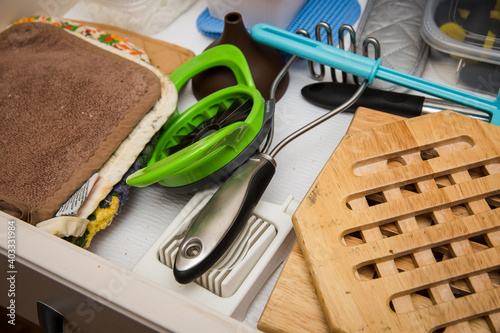 Kitchen drawer filled with potholders, trivets, and kitchen utensils photo