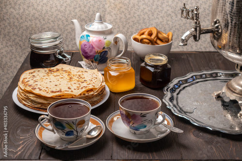 Tea party with samovar, crepes, bagels, honey, jam