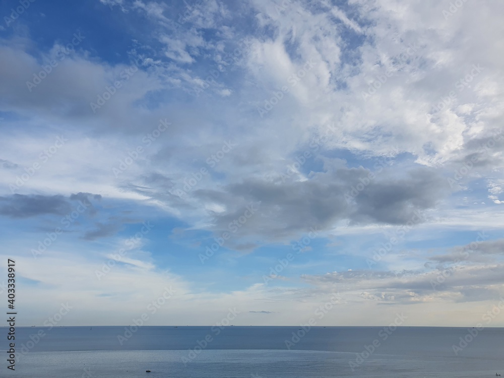 Bue ocean sea water with calm waves and cloudy sky horizon visible in the distance