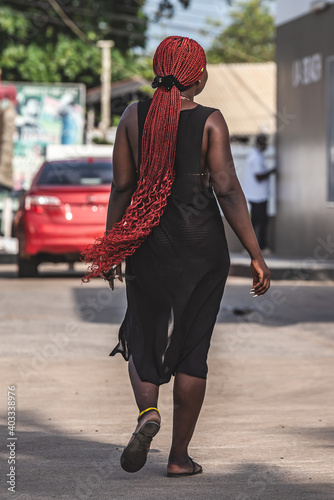 Africa woman walking on a street facing the beach in Labadi Accra Ghana West Africa photo