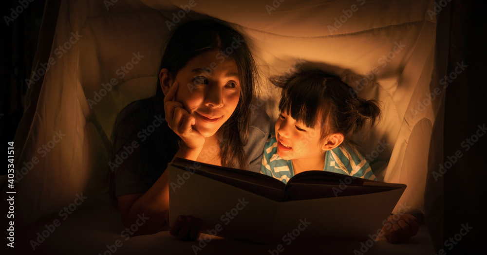 mom and daughter read bedtime stories on bed before getting to sleep mom and daughter read bedtime stories on bed before getting to sleep