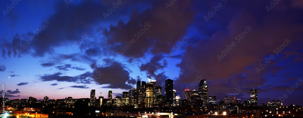 Montreal skyline panorama at dusk with illuminated buildings and cloud silhouettes