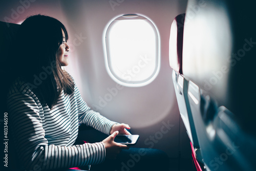 Teenage girl looking out of airplane window