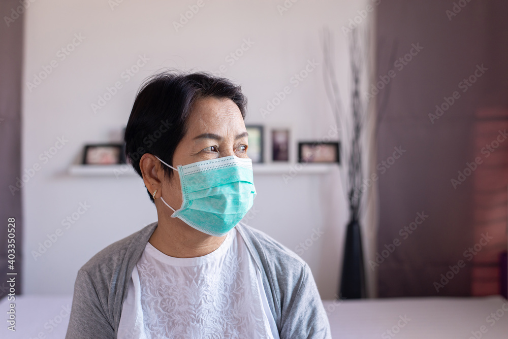 Elderly asian women wearing surgical masks protect corona virus or covid-19 during spreading at home,Social distancing,New normal,Coronavirus protection face mask Elderly asian women wearing surgical masks protect corona virus or covid-19 during spreading at home,Social distancing,New normal,Coronavirus protection face mask