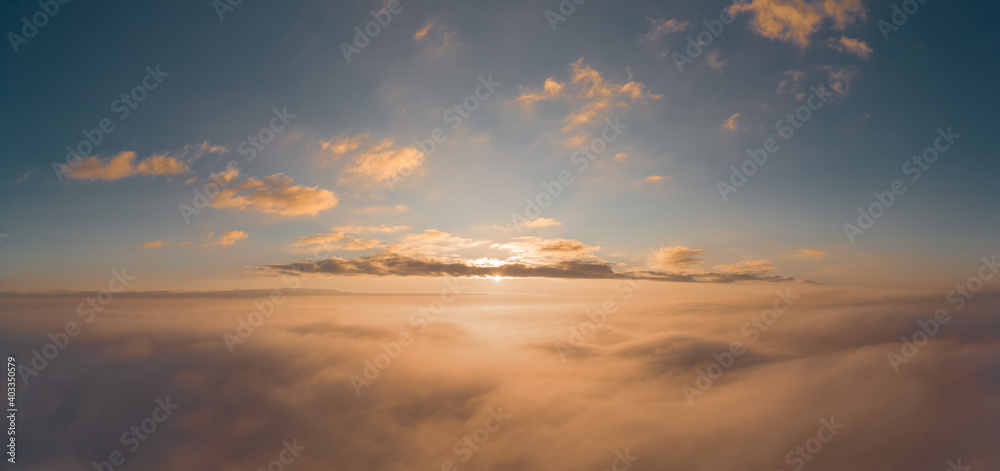 Sunrise panorama in orange and yellow colors. Sky background. View from an airplane during a vacation flight