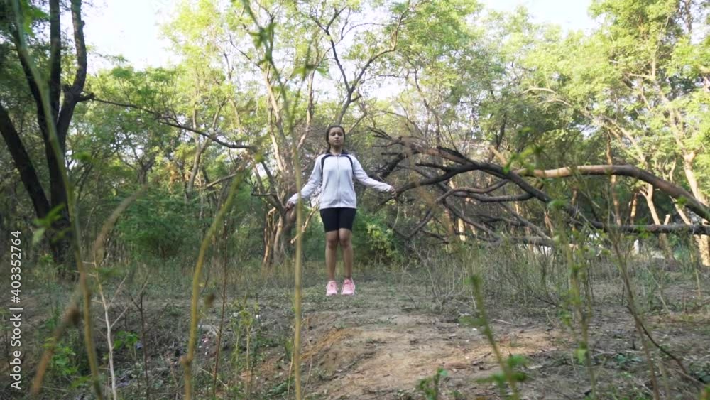 Athletic Beautiful Woman Exercises with Jump, Skipping Rope in the forest. Sporty woman in sportswear. Female doing fitness training in morning. Athletic Beautiful Woman Exercises with Jump, Skipping Rope in the forest. Sporty woman in sportswear. Female doing fitness training in morning.