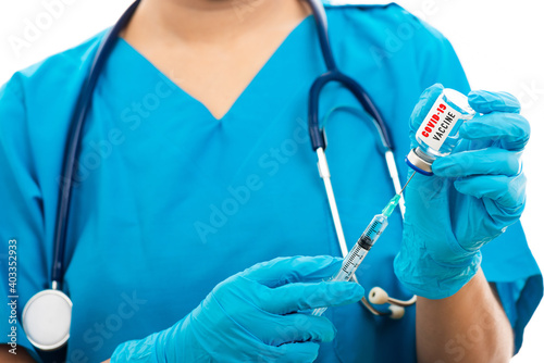 Female nurse with stethoscope puts on rubber gloves and wear medical face mask, woman doctor in blue uniform holding syringe . and COVID-19 vaccine, isolated white background, medical health concept