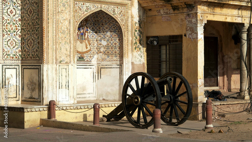 side view of an old cannon outside an entrance to city palace in jaipur