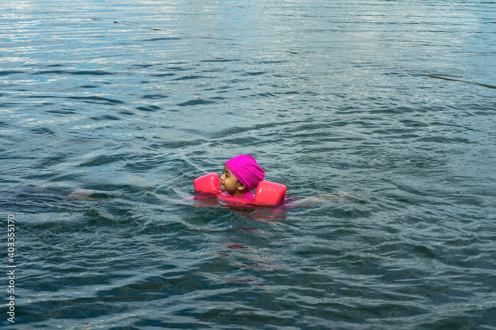 Closeup portrait of cute little girl swimming, happy child having fun in water, beach resort, summer vacation and holidays concept Closeup portrait of cute little girl swimming, happy child having fun in water, beach resort, summer vacation and holidays concept