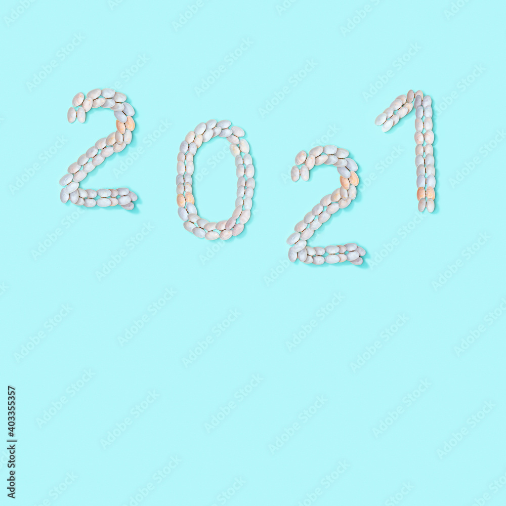 Naklejka premium Figure 2021 laid out of small similar natural seashells on blue paper. Summer design concept with shells