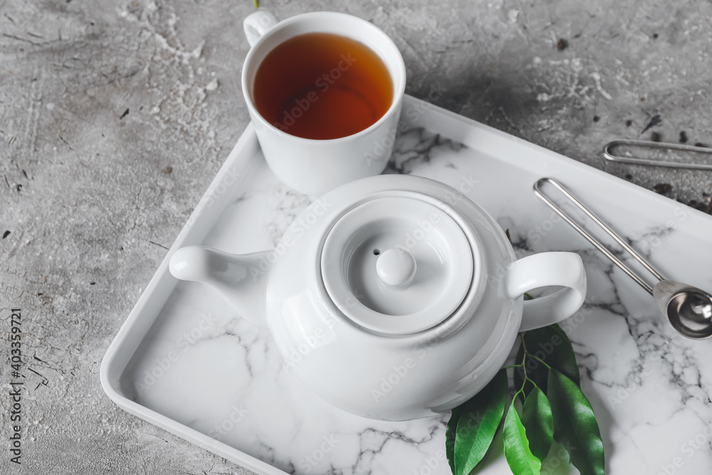 Beautiful teapot and cup of tea on table - obrazy, fototapety, plakaty 