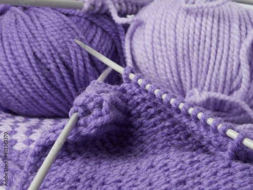 Needlework crochet, top view of yarn balls, flat spoon on light wood close-up