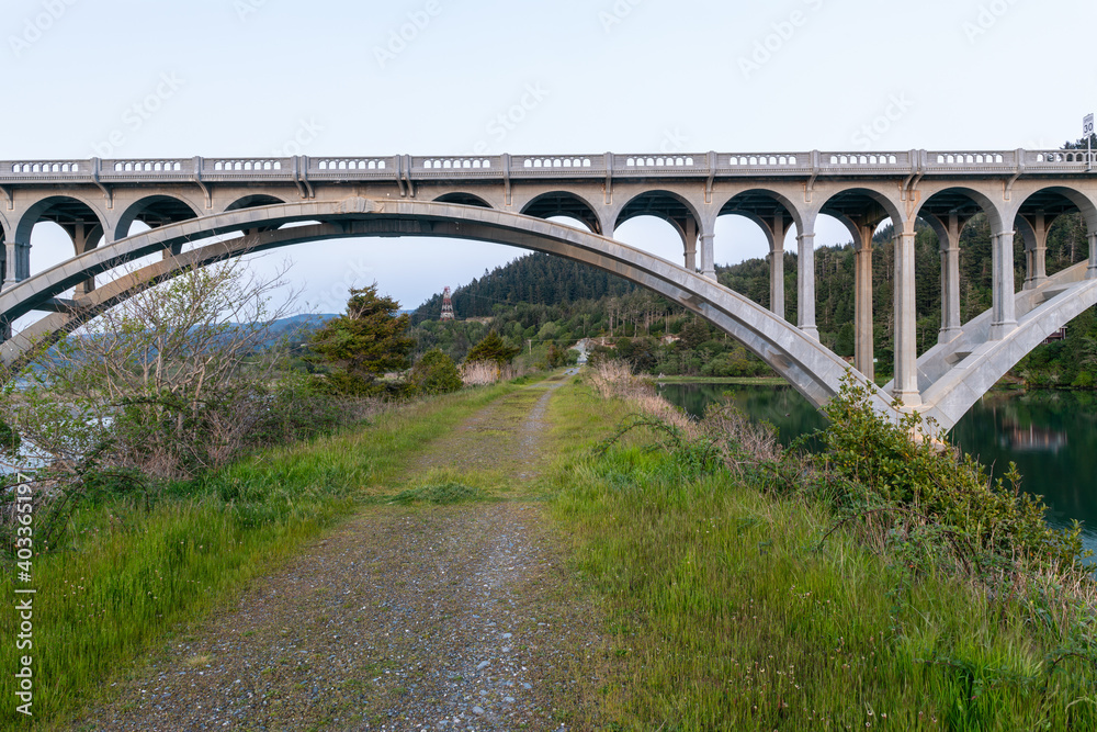 A gravel road runs under the Rogue River Bridge at Gold Beach, Oregon, USA