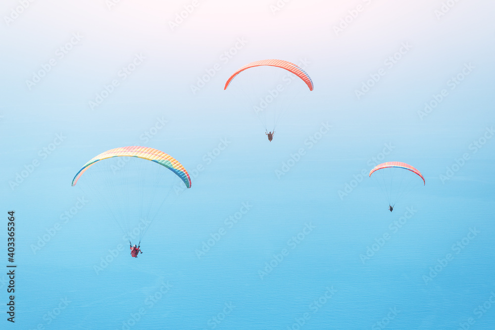Team of paragliders flying in the blue sky. Extreme and air activity and sport concept. Takeoff from famous spot on Babadag mountain Team of paragliders flying in the blue sky. Extreme and air activity and sport concept. Takeoff from famous spot on Babadag mountain